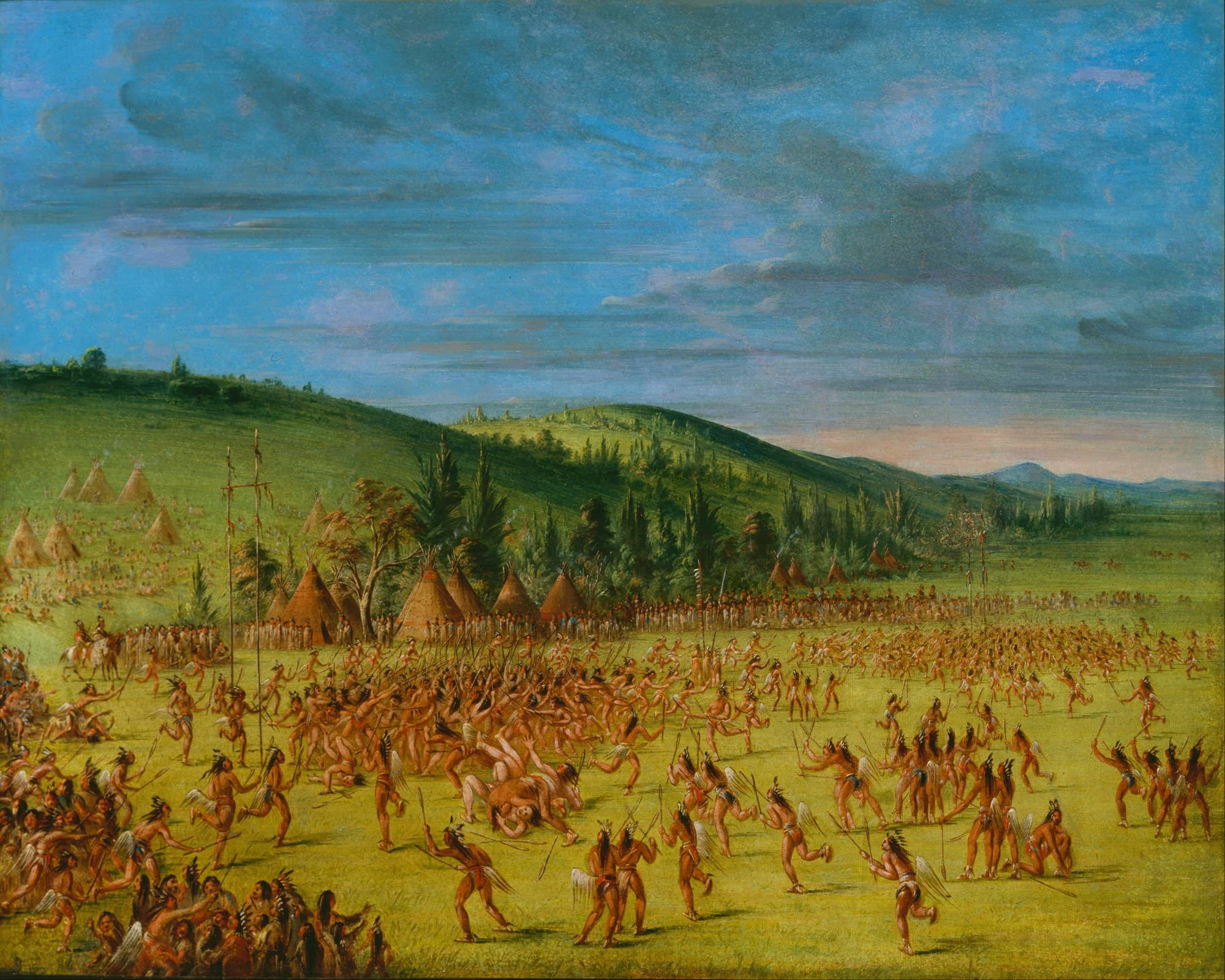 A painting of an enormous ball game on open grassland. Several hundred men with sticks are spread across the field, a knot of players is tangled together near the centre, long lines of spectators stand along the far side, and a village of conical dwellings sits below wooded hills.